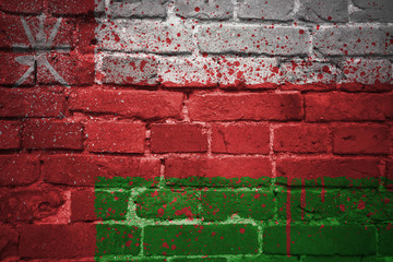 painted national flag of oman on a brick wall