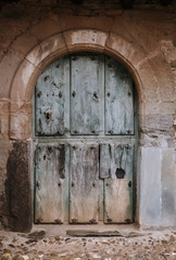 Old weathered wooden door in a stone wall in Castrillo de los Polvazares Leon, Spain