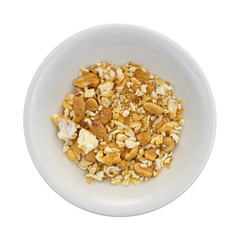 Toffee caramel popcorn crumbs in the bottom of a bowl isolated on a white background.