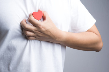 A man hand with wooden red heart object