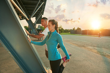 Male and female athletes stretching before going jogging outdoors