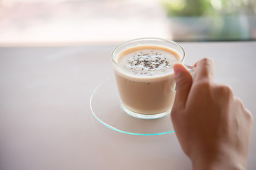 Woman's hand with  cup of coffee  in cafe. Coffee break time.