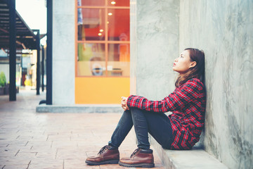 Upset woman sitting on the floor against grunge background.
