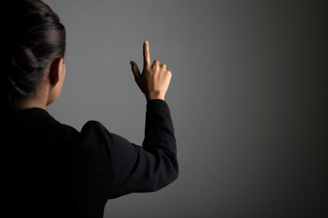 Business Woman in front of visual touch screen isolated on black