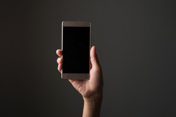 Woman hand with smartphone isolated on black.