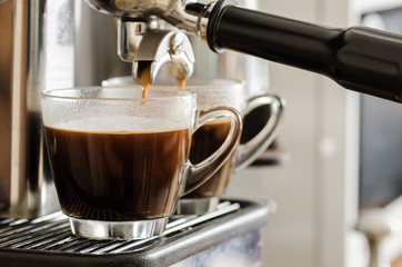 Coffee flowing into the cup from coffee machine