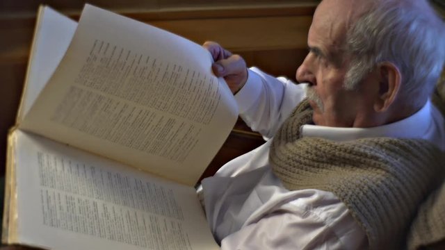 Aging Man is Reading Encyclopedia Furniture Bookshelves Are to the Right From Grandfather Reader With Old Book in Cosy Armchair Training His Memory