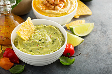 Guacamole and hummus in white bowls
