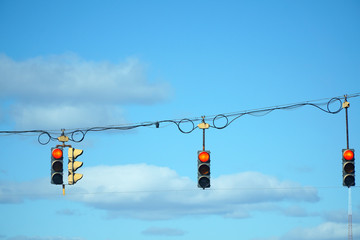 red traffic light hanging against sky