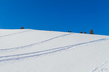 Snow slope on a blue sky background.