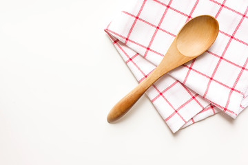 Wooden spoon and dish towel on white background