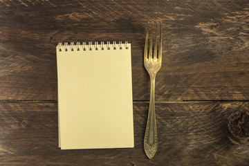 Vintage fork and notepad for copyspace, overhead shot