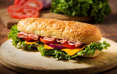 Sandwich with ham on a table, tomato and chees