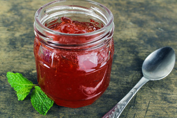 fresh strawberry jam in glass bottle with mint leaf