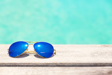 Blue sunglasses lying on a wooden deck