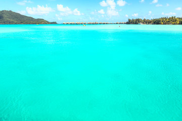 Stunning view of blue turquoise lagoon and far bungalows on back