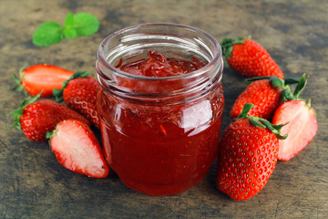 fresh strawberry jam in glass bottle with mint leaf