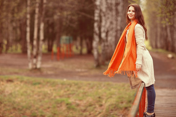 Obraz na płótnie Canvas young girl in an orange scarf on a walk in the park