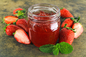fresh strawberry jam in glass bottle with mint leaf