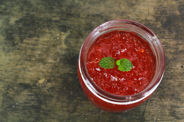 fresh strawberry jam in glass bottle with mint leaf