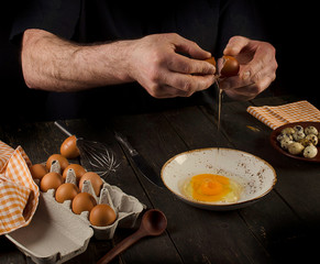 Man hands cracking an egg.