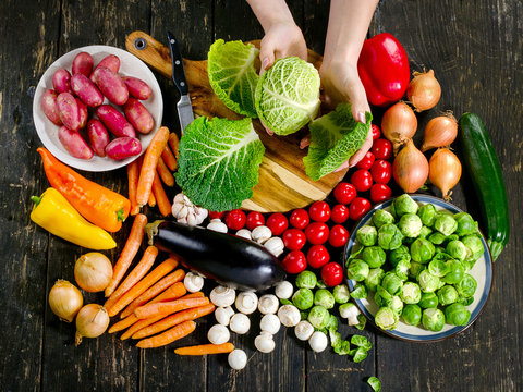 Woman Hands Cooking Vegetables On Dark Wooden Board.