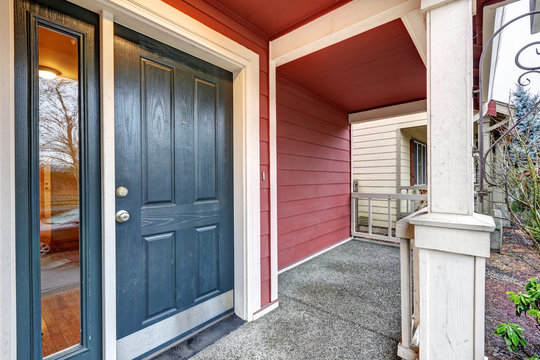Covered red porch with dark blue accent front door