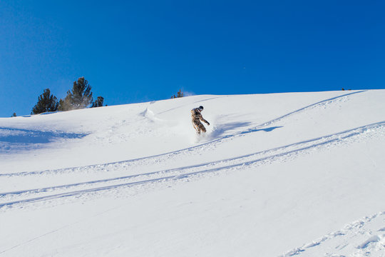 Snowboarder riding fresh snow.