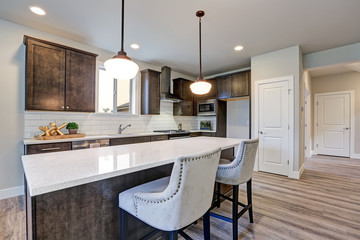 New kitchen boasts dark wood cabinets, large island