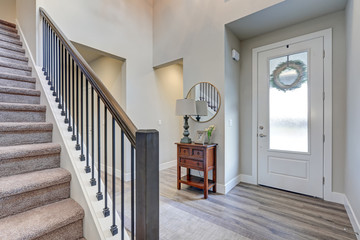 Grey foyer with high ceiling over laminate flooring,