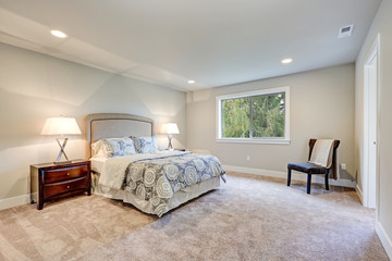 Elegant light filled master bedroom with queen bed