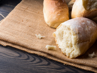 Freshly baked bread loaves on burlap dark wooden background. Texture closeup italian bakery products. Copy space