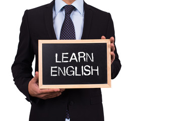 Businessman holding mini blackboard with LEARN ENGLISH message