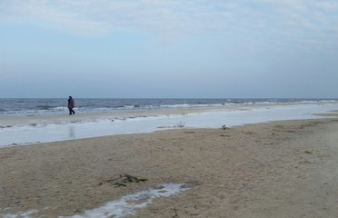 Einsame Spazierg&auml;ngerin am winterlichen Ostseestrand