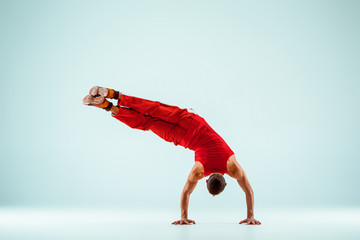 The gymnastic acrobatic caucasian man on balance pose