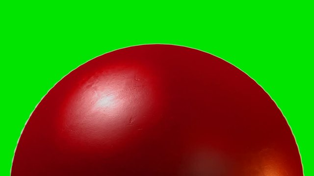 A closeup of a traditional red cricket ball with a leather stitched surface rotating once to create a loop able sequence on a green screen background - 3D render