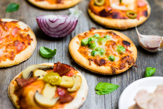 Different Types of Pizza with Ingredients on Wooden Background. Colorful Food Photo.