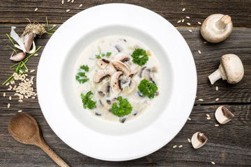 Soup with Fresh Mushrooms and Raw Ingredients on Wooden Background