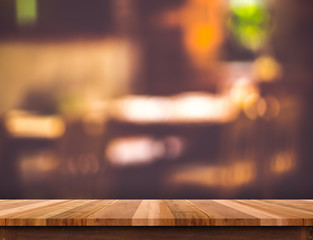 Empty brown wooden table and blurred restaurant bokeh light back