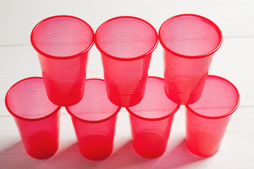 Stacked red plastic cups on a white wooden table