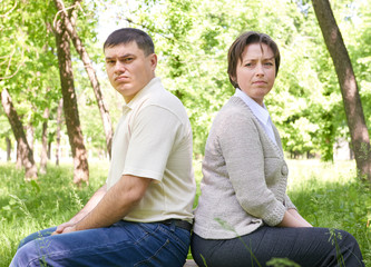 Unhappy couple in summer park. Face expression and grimace.