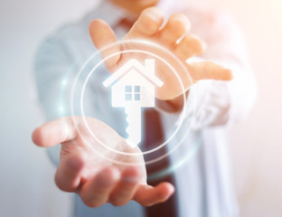 Obraz premium Businessman holding 3D rendering icon house in his hand
