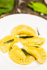 Fresh Ravioli and Salvia Food with Green Spinach Leaves on Background