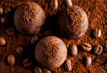Three dark chocolate sweets with coffee, top view