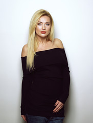 Fototapeta premium Beautiful blonde girl in a black dress. A variety of emotions.
