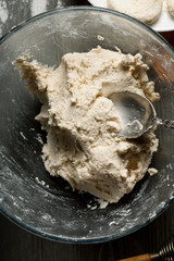 Dough with metal spoon in glass bowl, vertical