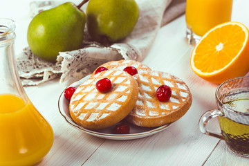 Delicious, delicious breakfast: cookies on a plate with berry fruit on the table. View from above. Close-up