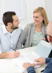 young couple signing property purchase contract