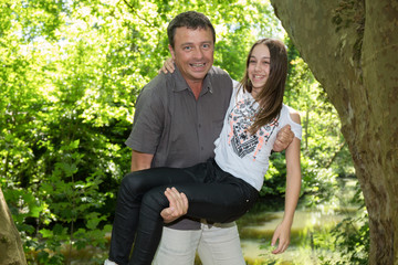 father has his teenage daughter in his arms