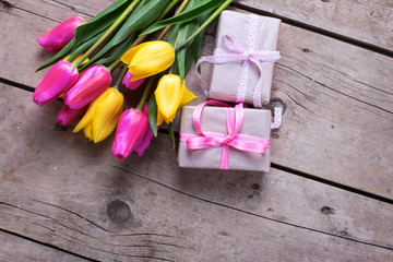 Bright tulips flowers  and boxes with presents on vintage wooden